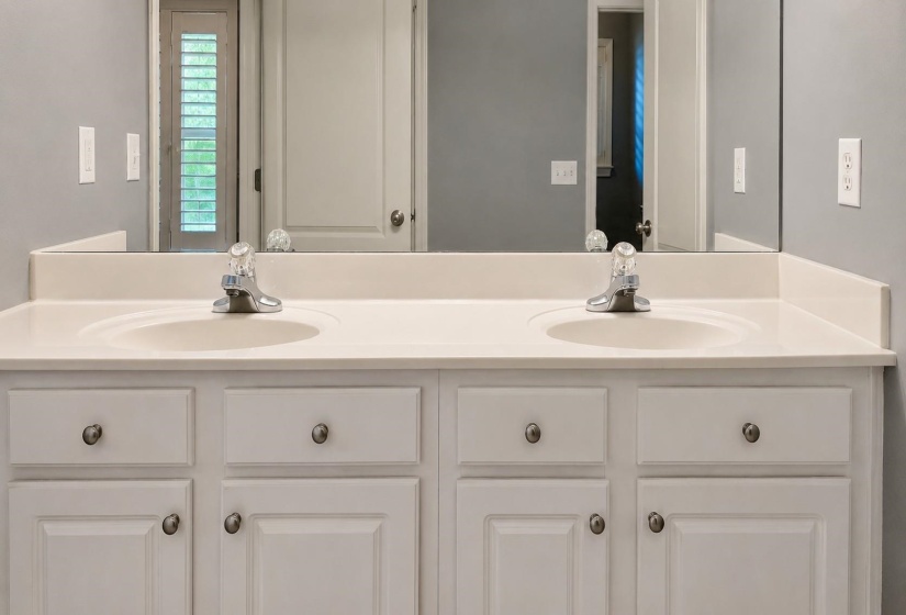 White dual vanity with integrated sinks, chrome faucets, a full-width mirror, and shaker-style cabinetry