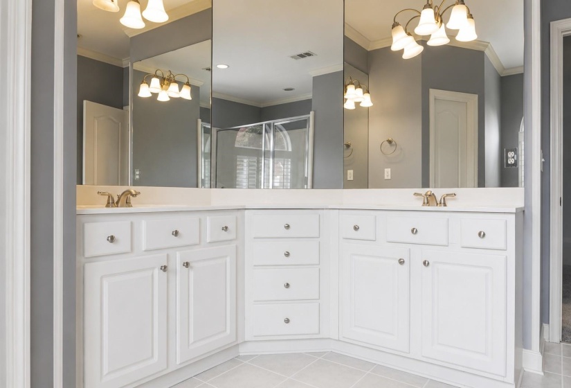 Dual vanity with white cabinetry and integrated sinks, complemented by brass-finish fixtures