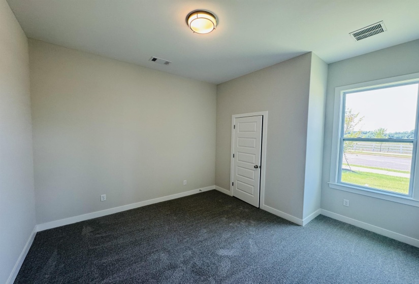 Unfurnished room with dark carpet and baseboards