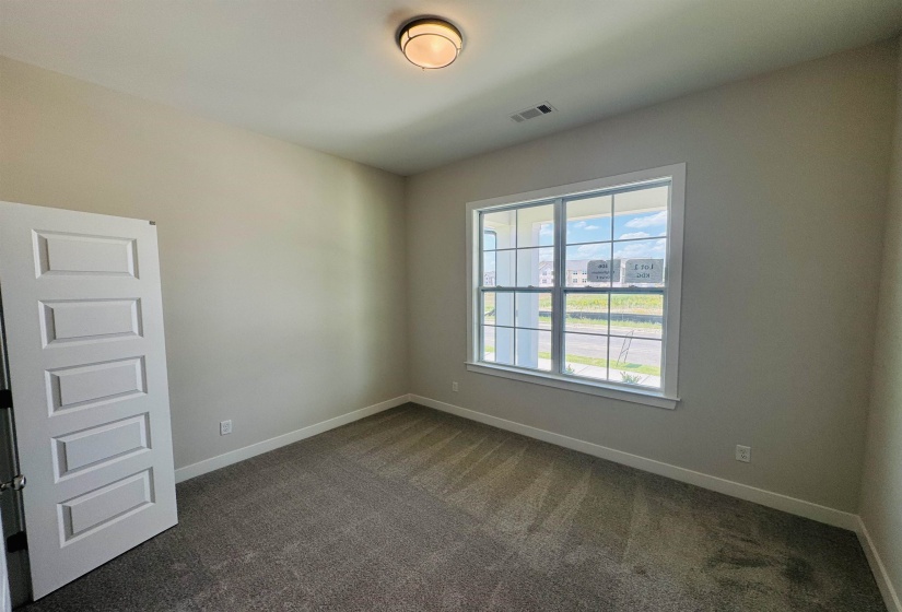 Spare room featuring baseboards and dark carpet