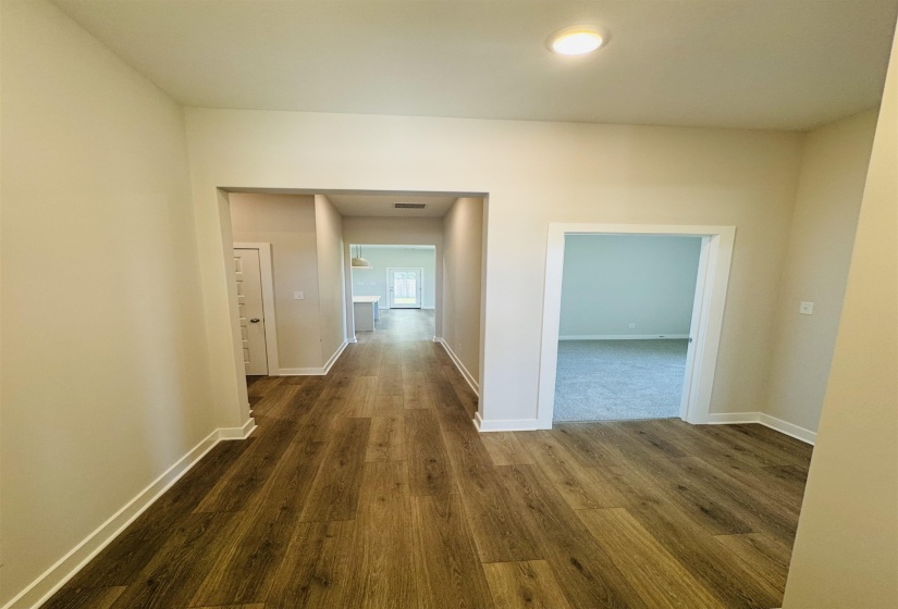 Corridor featuring dark wood-type flooring and baseboards