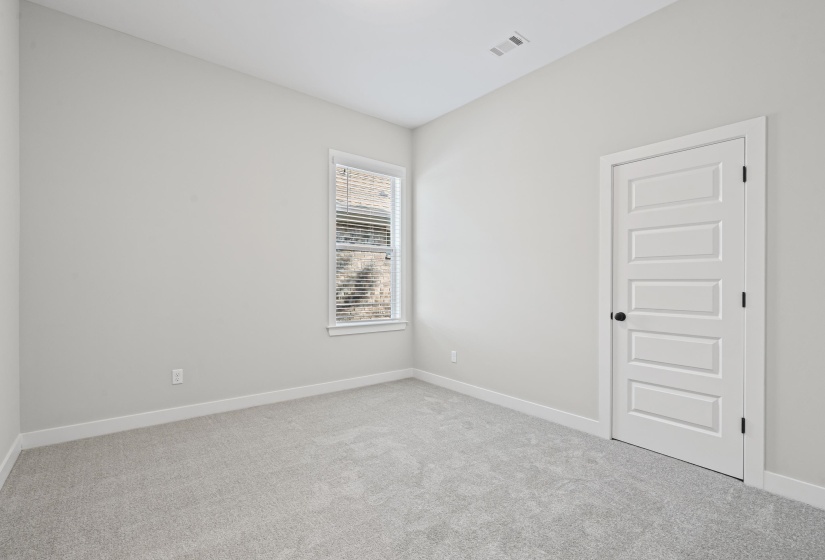 Empty room featuring light colored carpet and baseboards