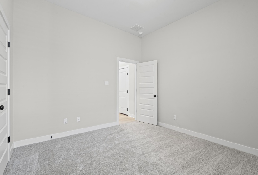 Spare room featuring light colored carpet and baseboards