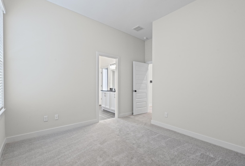 Unfurnished room featuring light carpet and baseboards