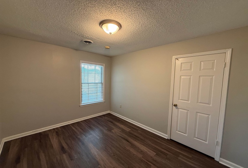 Room featuring wood-finish flooring, neutral wall paint, and white baseboards