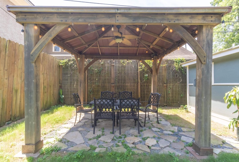 Wood-frame gazebo featuring a ceiling fan, recessed lighting, and flagstone flooring