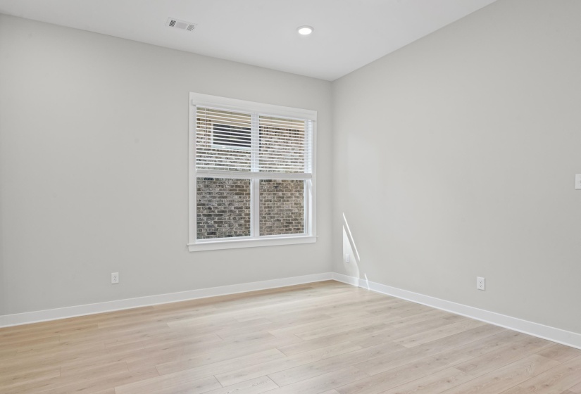 Empty room with light wood-type flooring and recessed lighting
