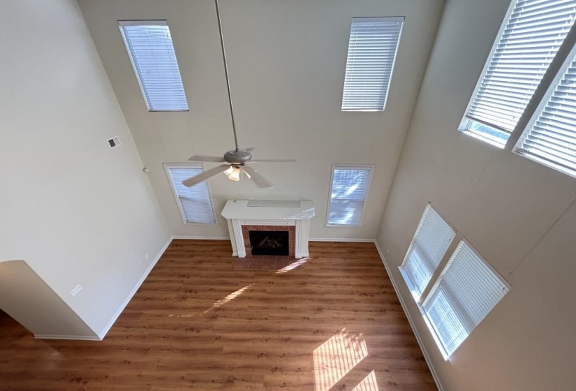 Unfurnished living room with a high ceiling, a fireplace, dark hardwood / wood-style floors, and plenty of natural light