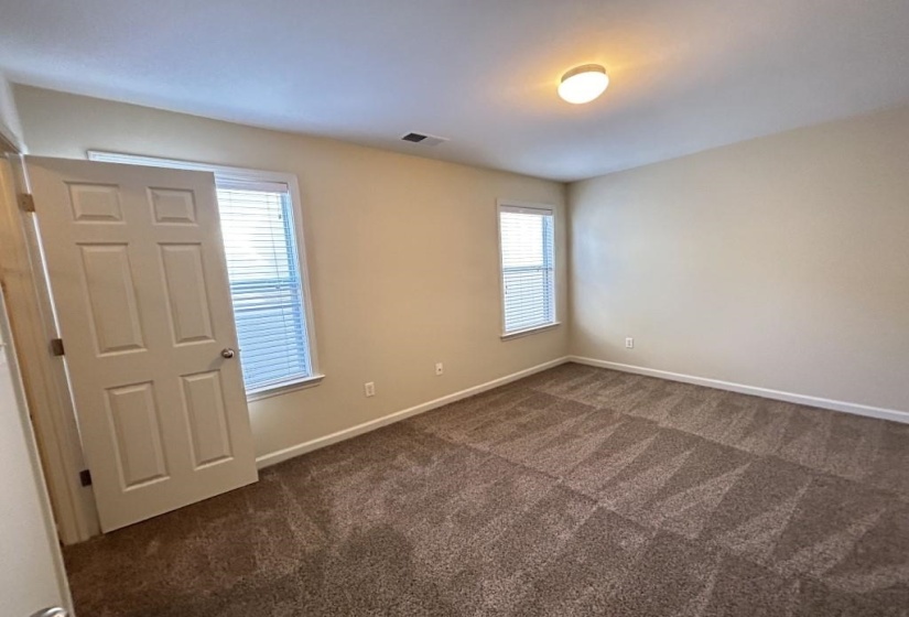 Spare room featuring dark carpet
