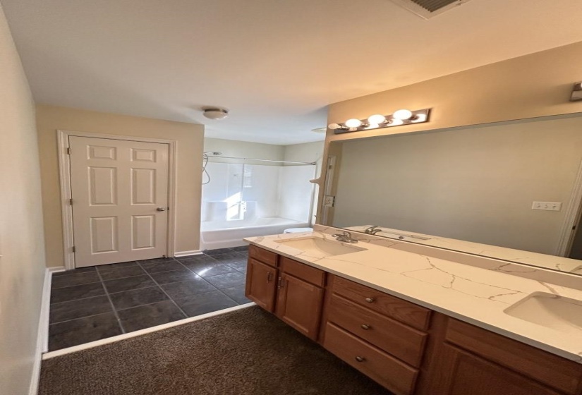 Bathroom with bathing tub / shower combination, vanity, and tile patterned floors