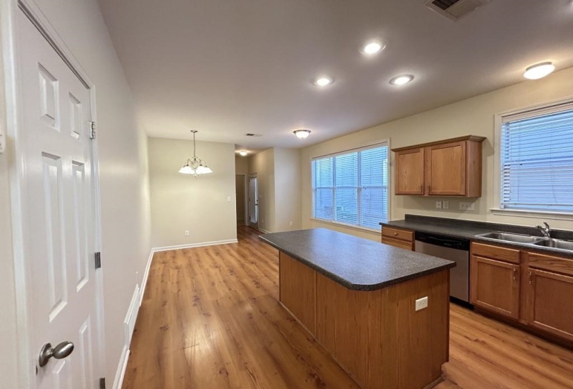 Kitchen with dishwasher, light hardwood / wood-style floors, a center island, and sink