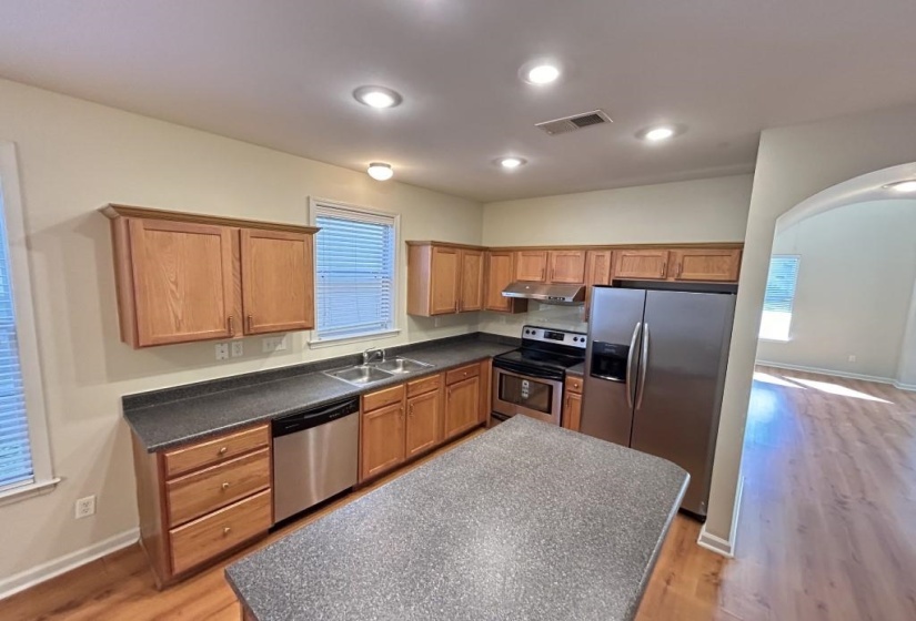 Kitchen with light wood-type flooring, appliances with stainless steel finishes, and sink