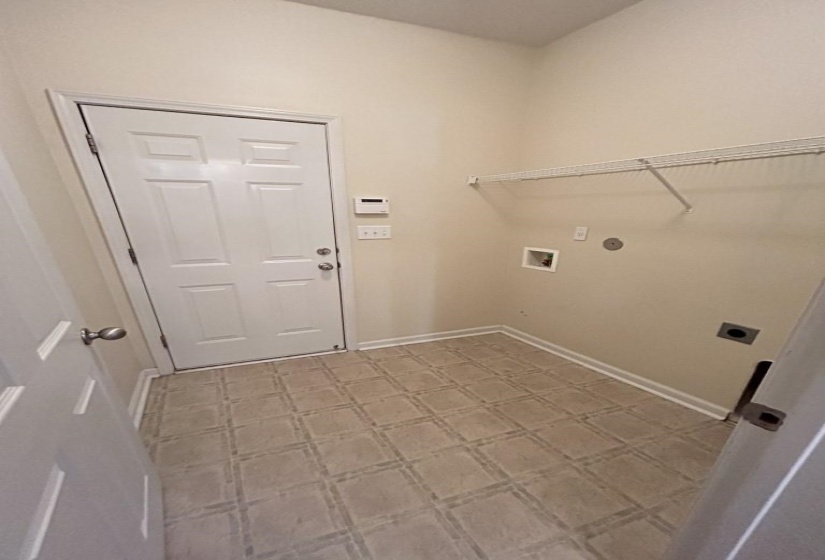 Clothes washing area featuring washer hookup and hookup for an electric dryer