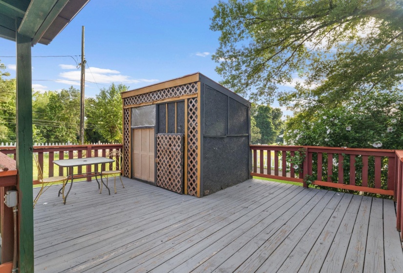 Expansive outdoor deck featuring wood flooring and red-stained railings