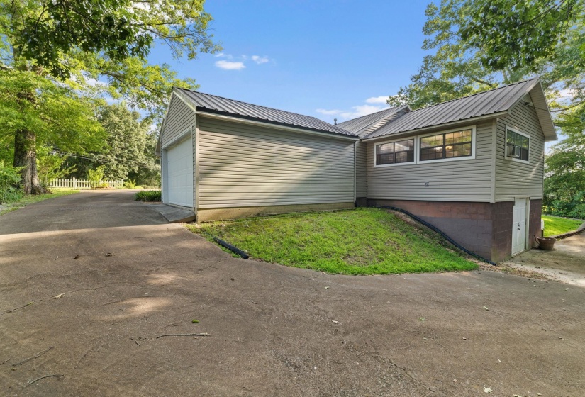 Expansive paved driveway leading to an attached garage with a white overhead door