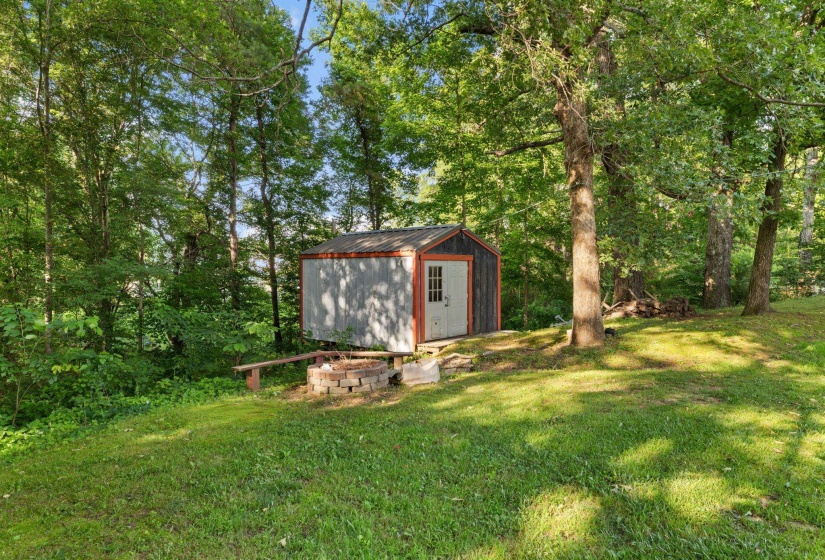 Expansive grassy area featuring a storage shed with a light-colored door and dark trim
