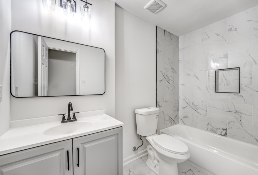 Bathroom featuring a white vanity with a light gray cabinet, a white sink, and a matte black faucet