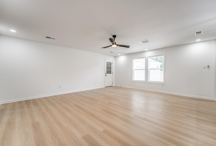 Expansive room featuring wood-finish flooring, recessed lighting, and a contemporary ceiling fan