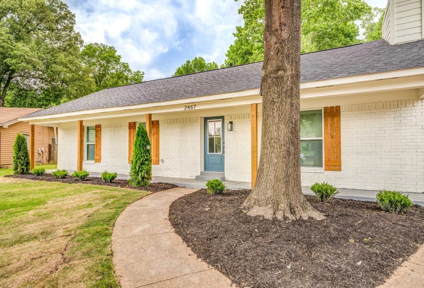 White painted brick exterior with dark shingle roofing
