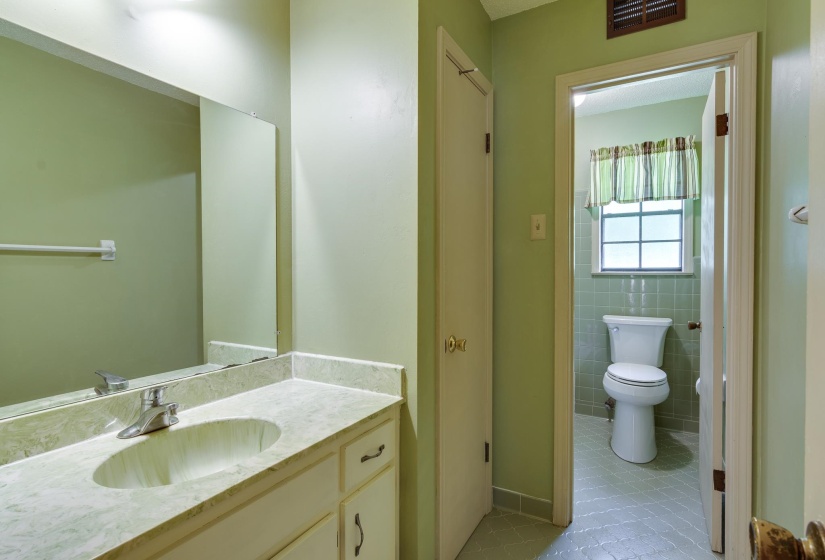 Bathroom featuring a white bathtub, ceramic wall tiling, and a window with privacy glass