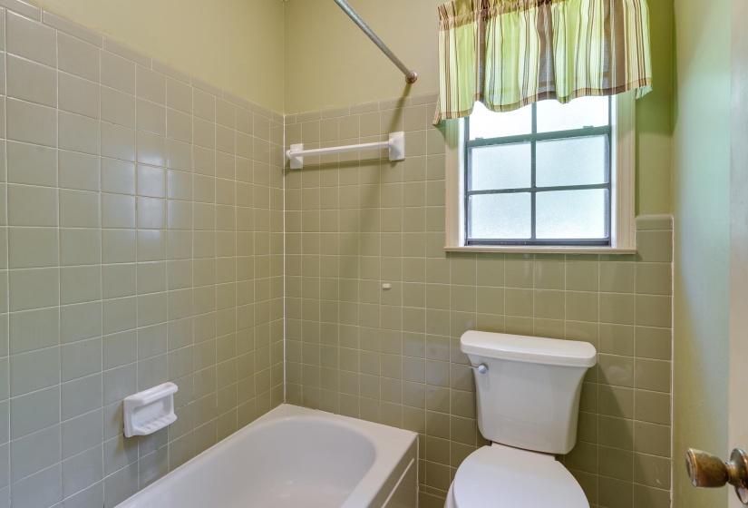 Carpeted room featuring a ceiling fan with integrated lighting, white walls, and wood trim