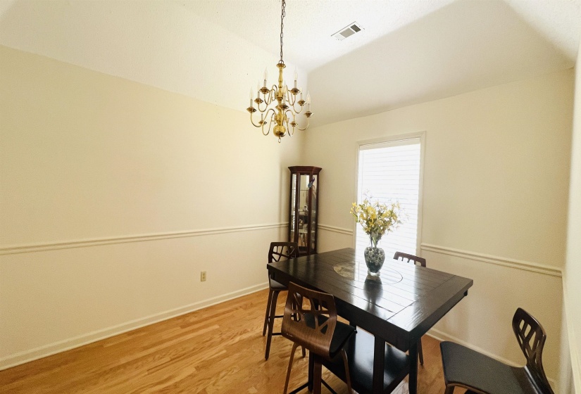 Dining area featuring light wood-finish flooring and a tray ceiling