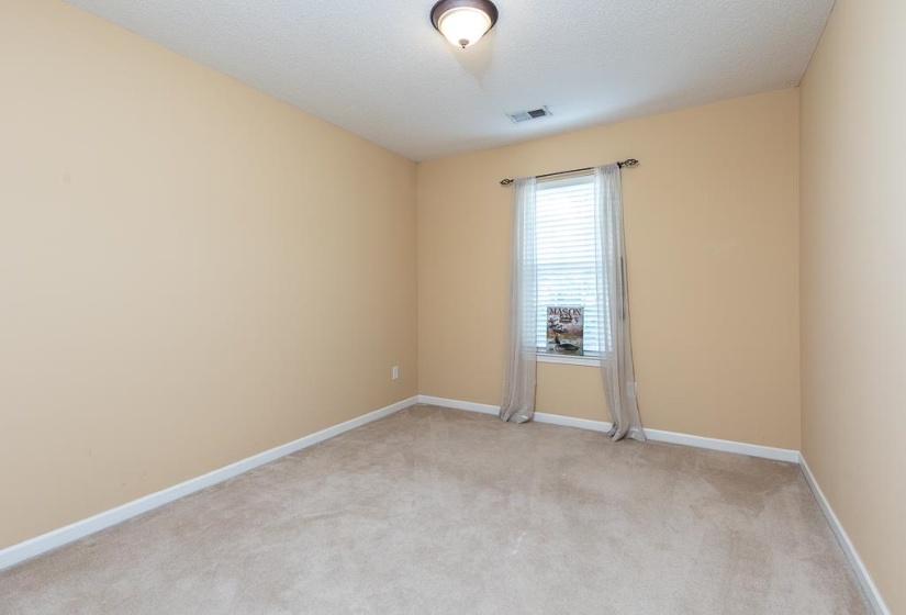 Carpeted room with Extra Large Almost Walk-In Closet,  neutral-toned walls, white trim, and a single window featuring horizontal blinds.