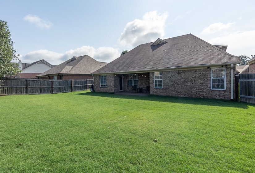 Expansive green lawn with a full privacy fence