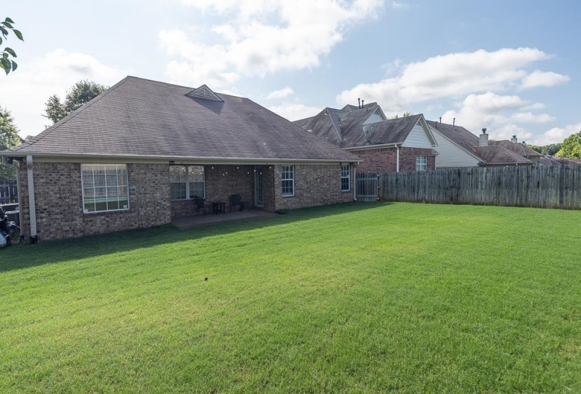 Expansive green lawn with a full wooden privacy fence