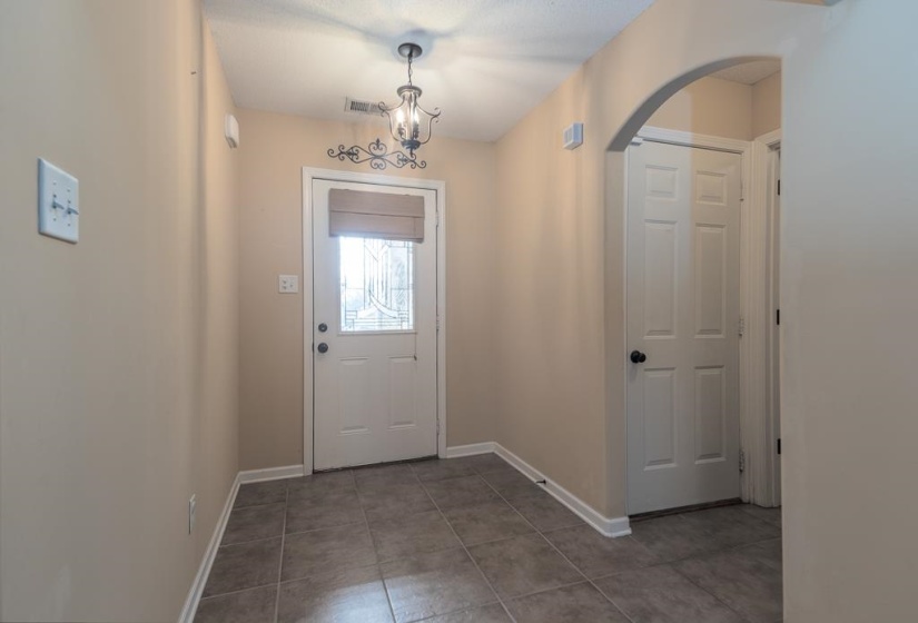 Entryway featuring LVP flooring and a Decorative Ceiling Fan/Light. Laundry Room Behind Open Entry Area as you walk in.