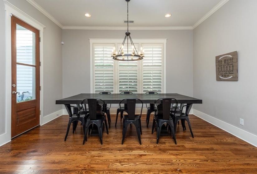Breakfast area featuring rich wood-finish flooring, a contemporary chandelier, recessed lighting, and a window with plantation shutters