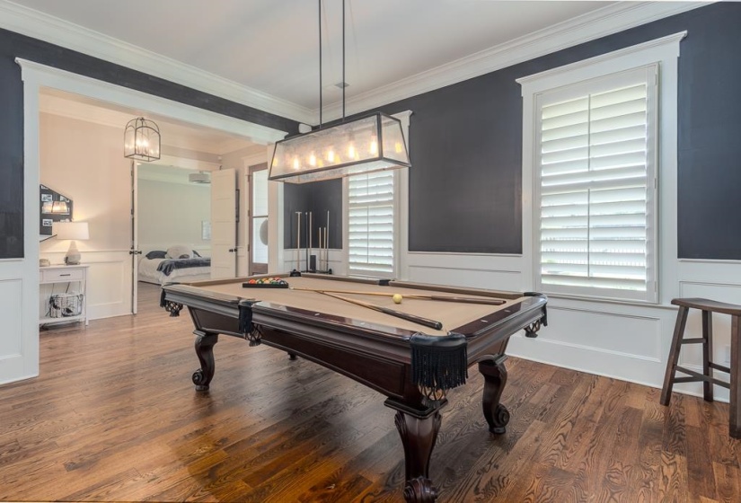 Hardwood flooring throughout, illuminated by a rectangular chandelier