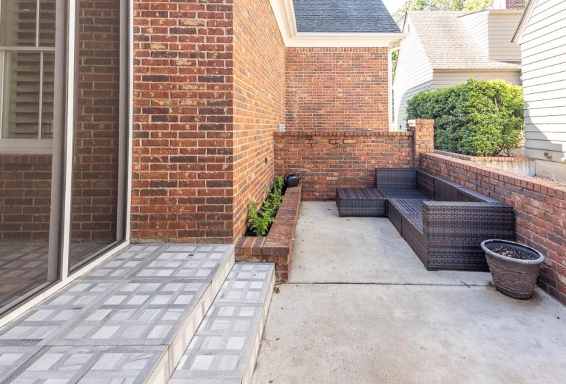 Private patio area featuring brick walls and concrete flooring
