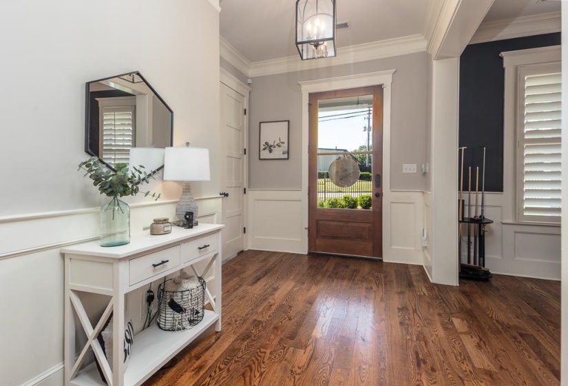 Warm wood-finish flooring complements the detailed wainscoting and crown molding