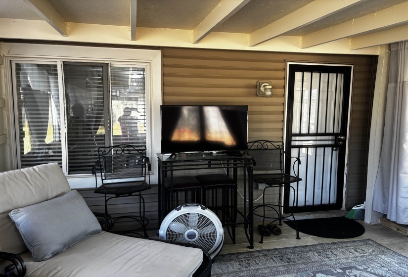 Covered patio featuring a sliding glass door, a security screen door, and horizontal siding