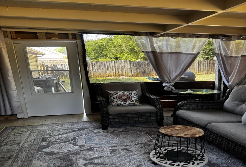 Covered patio area featuring wood-finish flooring and a white exterior door