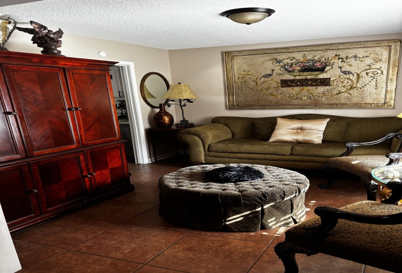 Warm-toned ceramic tile flooring, neutral painted walls, and a white textured ceiling