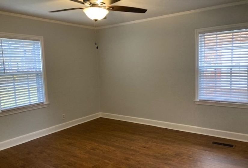 Spare room featuring ornamental molding, dark hardwood / wood-style flooring, and ceiling fan