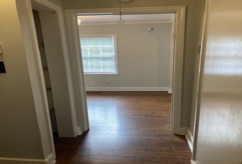 Hallway featuring crown molding and dark hardwood / wood-style flooring