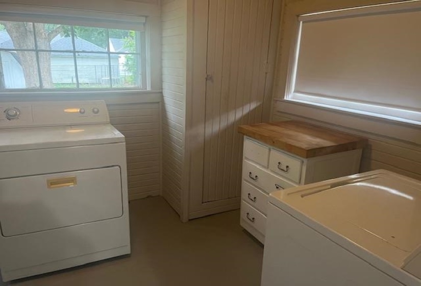 Clothes washing area with washer / clothes dryer and wood walls
