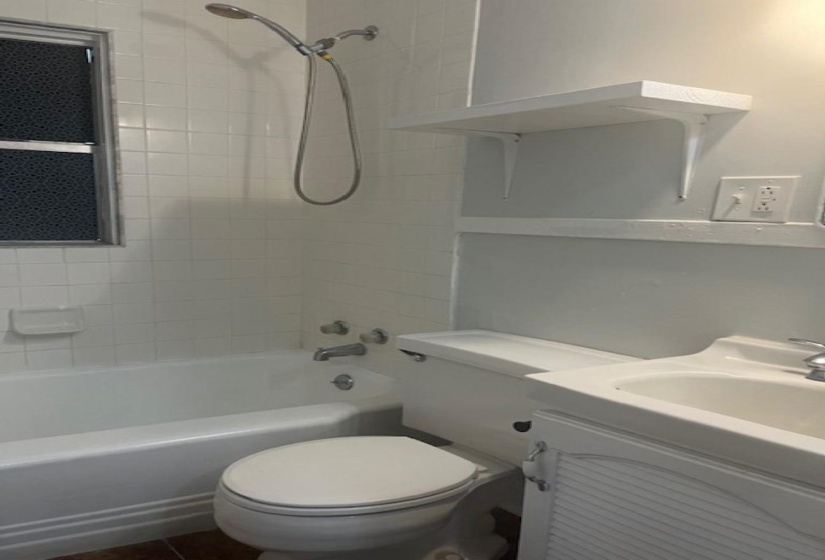 Full bathroom with vanity, tiled shower / bath combo, and toilet