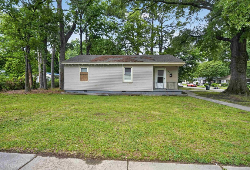 Single-story dwelling with light-colored siding, a covered front entry, and a paved walkway