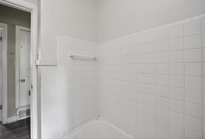 White subway tile shower surround with integrated soap dish and a towel bar