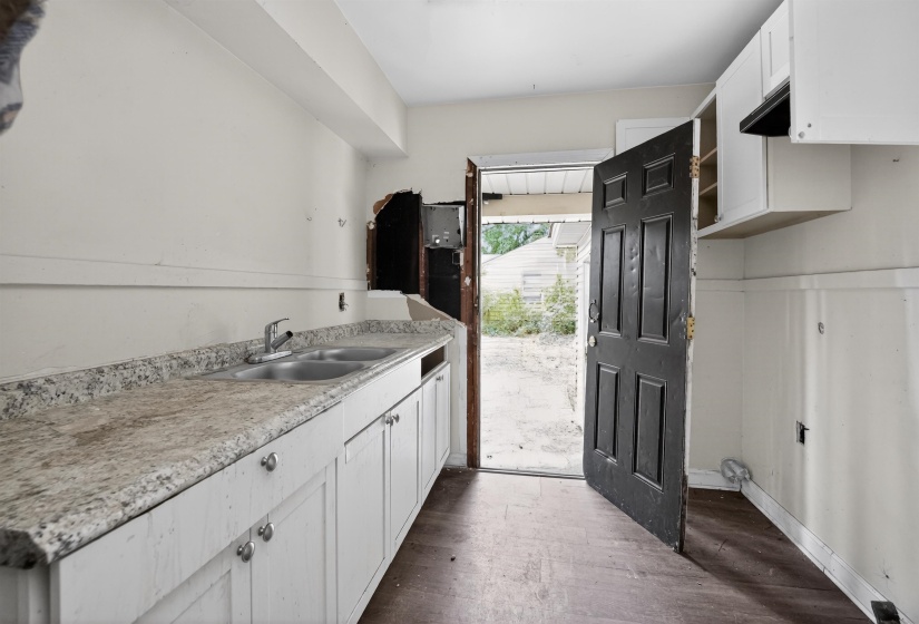 Kitchen featuring white cabinetry, a double basin stainless steel sink with a chrome faucet, and wood-finish flooring