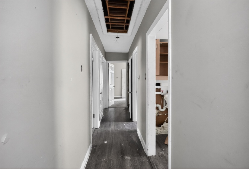 Interior hallway featuring wood-finish flooring and multiple doorways