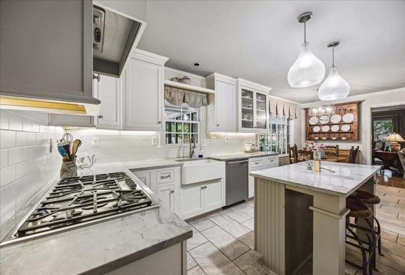 Bright kitchen featuring white cabinetry, quartzite countertops, Thermador gas range, and a farmhouse sink