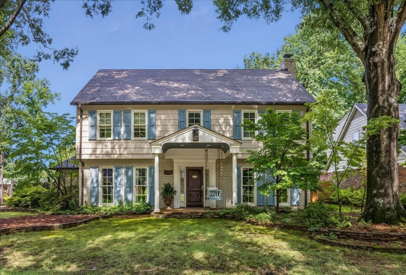 Two-story traditional exterior featuring light-colored siding and a dark shingle roof