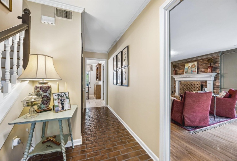 Foyer featuring brick-patterned flooring and crown molding
