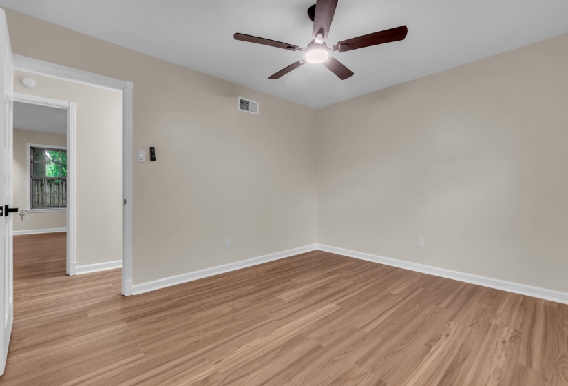 Room featuring wood-finish flooring, light-toned walls, and white trim