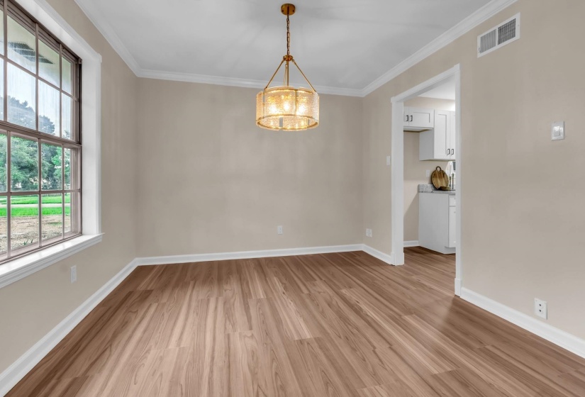 Interior space featuring wood-finish flooring, a contemporary drum chandelier, and a large window with white trim